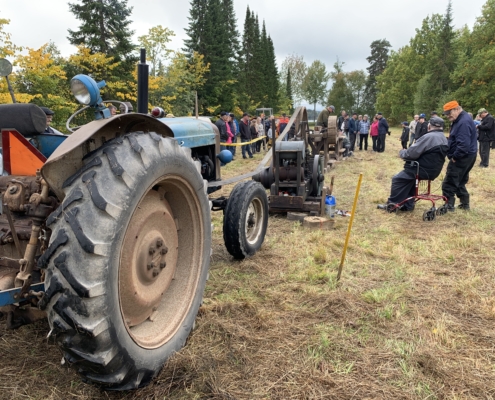 Torpparihulinoissa kartanon pihamaalla työkoneita esillä, mm. traktori.